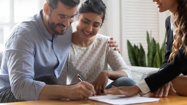 A happy couple playfully signing legal documents to make their relationship official.