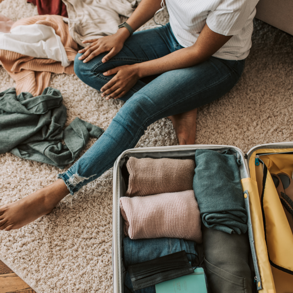 Honeymoon packing essentials laid out on a bed, including clothes, toiletries, and accessories